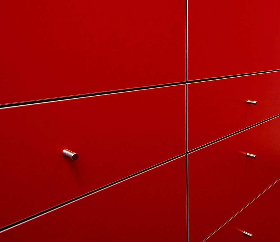 Red custom designed cabinets with metallic hardware