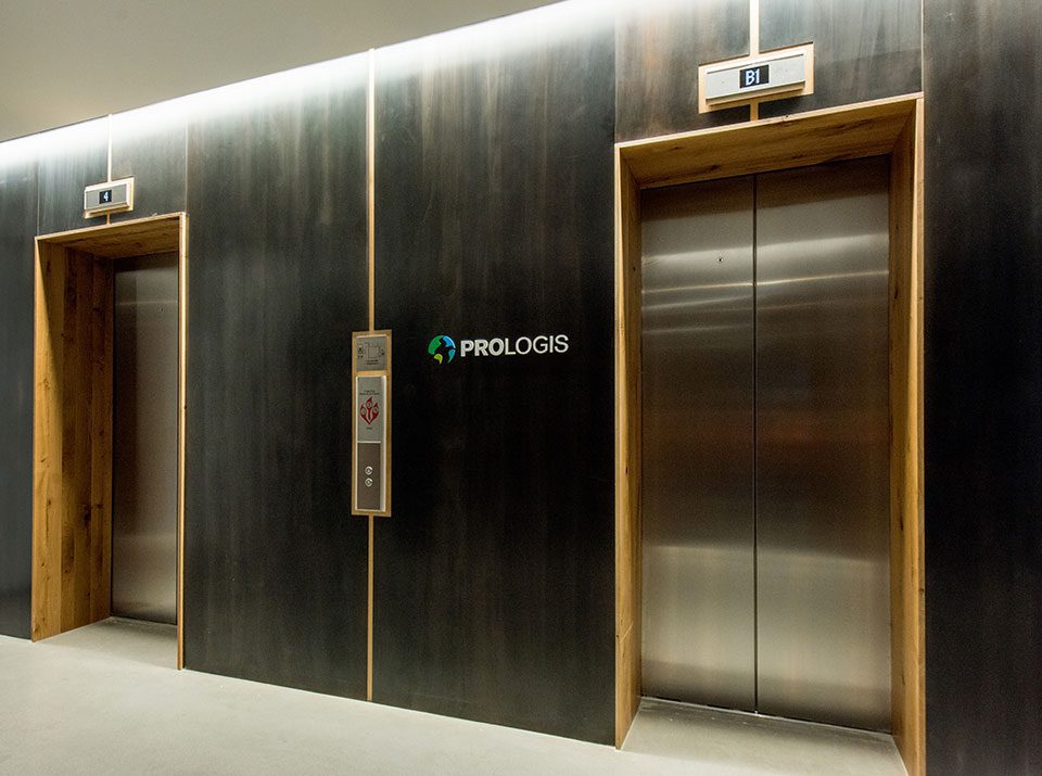 Elevator lobby with wood wall paneling and metal detail