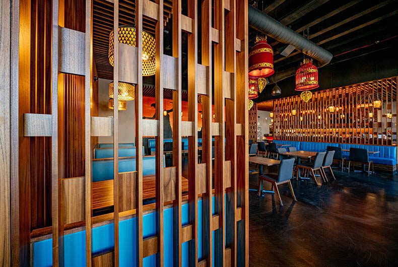 Restaurant seating area with intricate wood dividing walls and wood ceiling beams