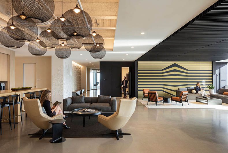 Office lounge with custom kitchenette, decorative wood ceiling panels and a wood-wall art installation