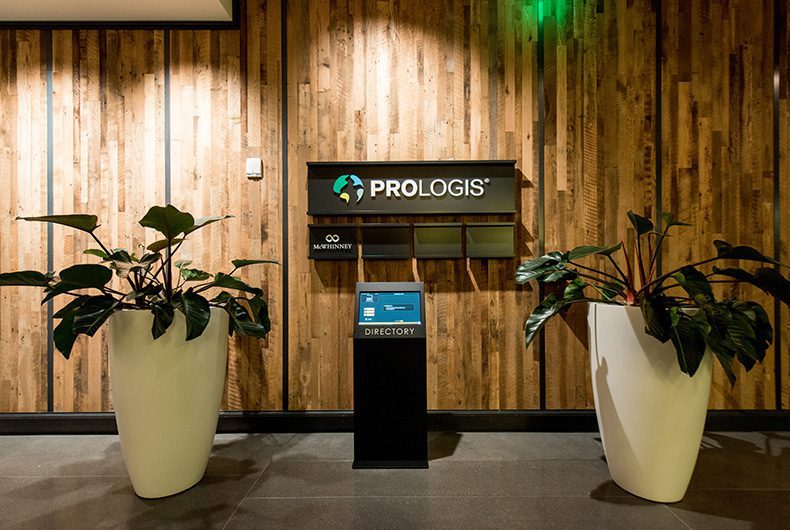 Office lobby with wood paneled walls and kiosk stand