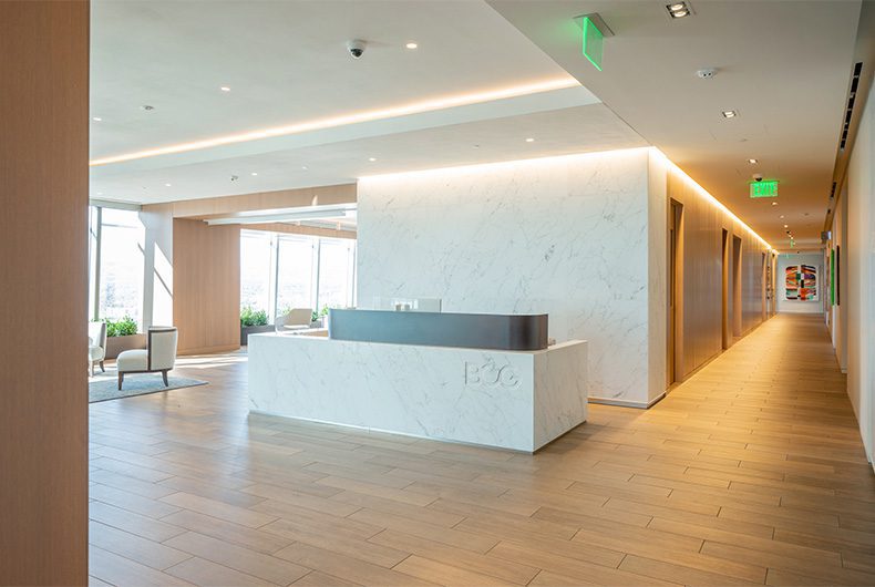 Office entry way with decorative wood-paneled admin desk and spacious wood-floor lobby