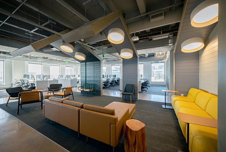 Office sitting lounge with hanging wood ceiling panels with mounted lighting