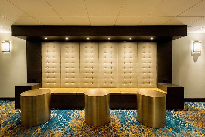 Hotel lobby built in bench with wood framing and upholstered seating and backboard.