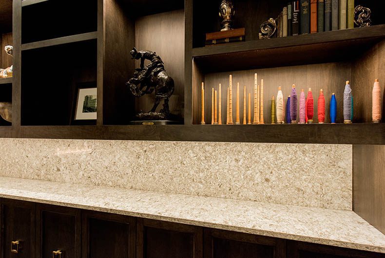 Wood built-in shelving and cabinetry with marble countertop and backsplash