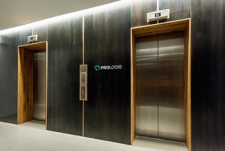 Elevator lobby with wood wall paneling and metal detail