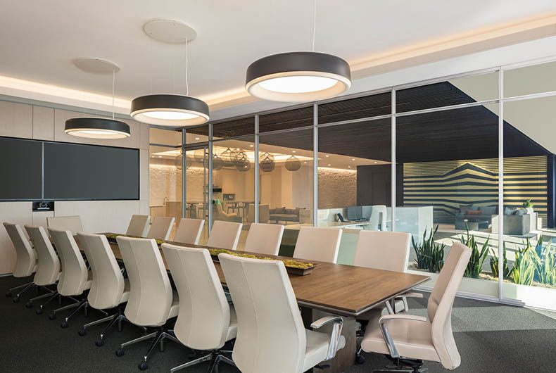 Conference room with long wooden conference table and a glass paneled wall