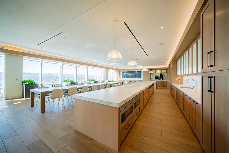 Office breakroom with kitchenette cabinetry, countertops and extra-large dining table