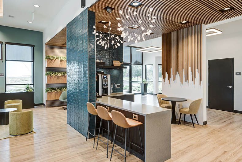 Break room area with kitchenette, wood-paneled partitions, and a seating area