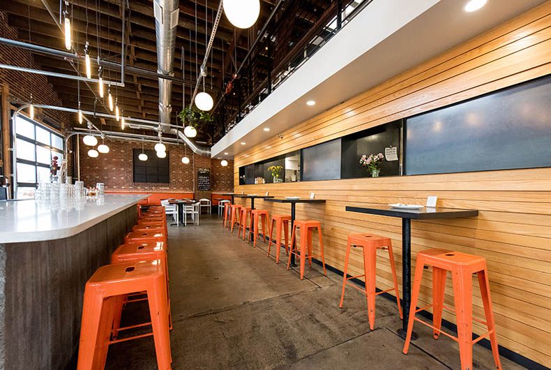 Restaurant bar with table top seating and wood paneled walls