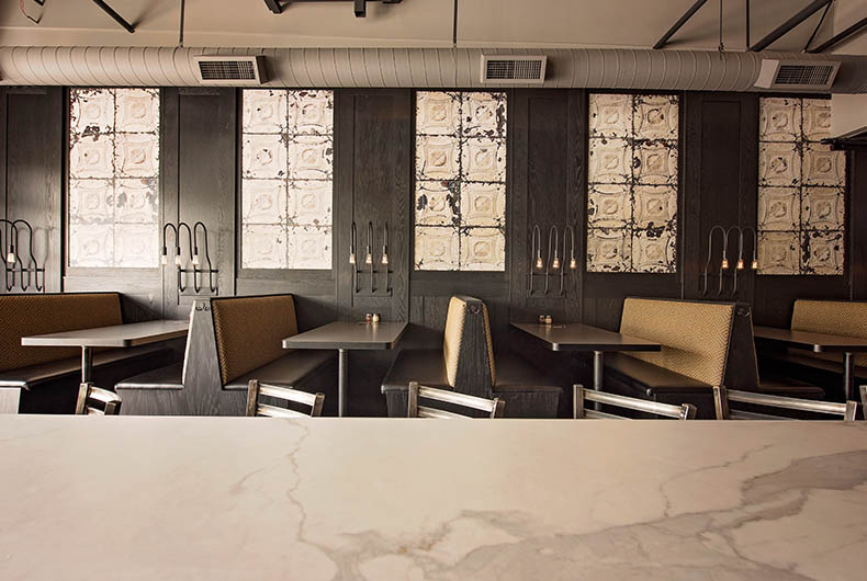 Restaurant dining area with built-in booths and decorative antique-finish wall panels