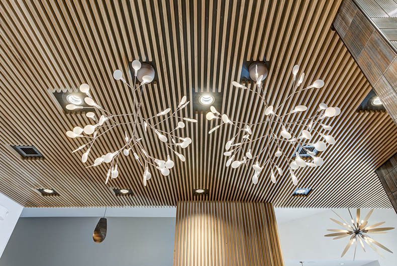 Wood-paneled ceiling system with installed decorative lighting