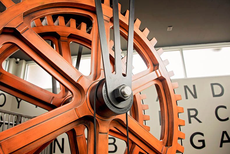 Large art piece installation of orange gigantic gear system