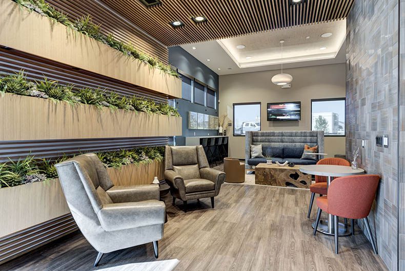 Sitting lounge with wall mounted planter system, a wood paneled wall and ceiling system