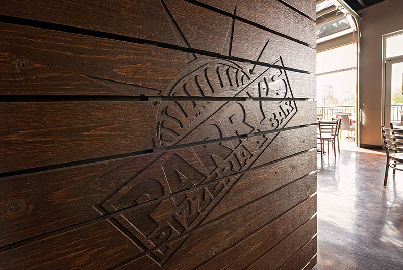 Hostess desk with wood paneling and engraved sign of restaurant