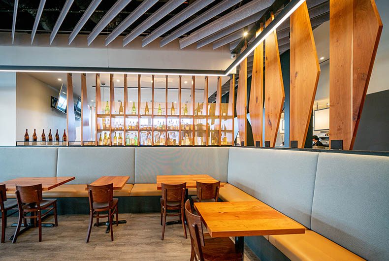 Restaurant banquette seating with upholstered backing and decorative wood partitions