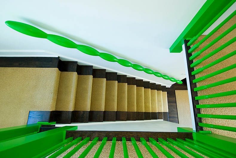 Custom decorative wood stairs and green hand railings